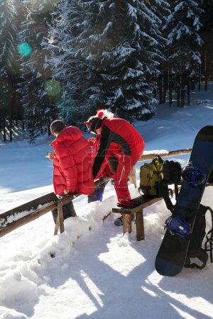 Téléchargez les photos : Les freeriders se reposent dans la forêt d'épinettes neigeuses lors de la journée ensoleillée d'hiver. Vacances de Noël dans les Carpates, Ukraine. Localisation à distance. - en image libre de droit