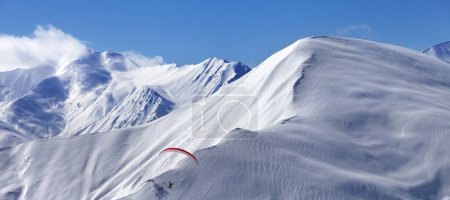 Foto de Vista panorámica de la velocidad volando en montañas nevadas iluminadas por el sol. Montañas del Cáucaso. Georgia, región Gudauri en invierno. - Imagen libre de derechos