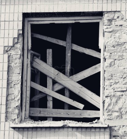 Téléchargez les photos : Boarded window of old destroyed house. Black and white retro toned image. - en image libre de droit