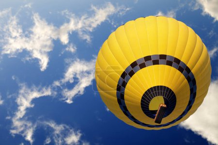 Téléchargez les photos : Yellow hot air balloon on blue sunlight sky with clouds. Bottom view. - en image libre de droit