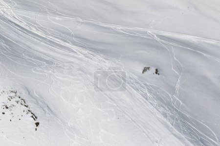 Photo for Snowy off-piste slope with traces of skis and snowboards. Caucasus Mountains in sun winter day, Georgia, region Gudauri. - Royalty Free Image