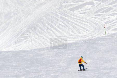 Photo for Snowboarder downhill on snowy ski trace at sunny cold day. Caucasus Mountains in winter, Georgia, region Gudauri, mount Kudebi. - Royalty Free Image