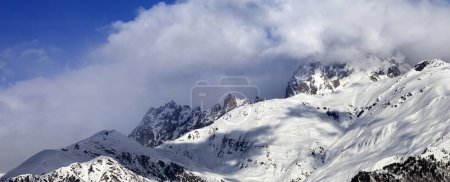 Panoramablick auf verschneite Berge in Wolken am Tag der Wintersonne. Berge Uschba, Kaukasusgebirge. Region Svaneti in Georgien.