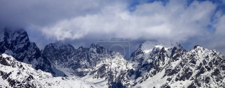 Foto de Vista panorámica de las rocas nevadas en las nubes en el soleado día de invierno. Montañas del Cáucaso. Región de Svaneti, Georgia. - Imagen libre de derechos