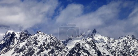 Foto de Vista panorámica sobre rocas nevadas y cielo azul con nubes en el soleado día de invierno. Montañas del Cáucaso. Georgia, región Svaneti - Imagen libre de derechos