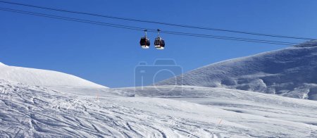 Photo for Panoramic view on gondola lift at ski resort and snowy off-piste slope with trace from skis and snowboards. Caucasus Mountains in winter, Georgia, region Gudauri. - Royalty Free Image