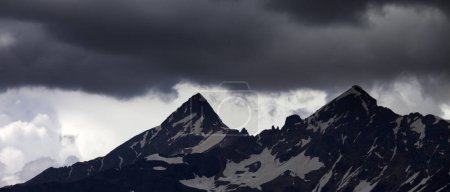 Foto de Vista panorámica sobre nubes de tormenta en altas montañas nevadas. Montañas del Cáucaso. Georgia, región Svaneti en verano. - Imagen libre de derechos