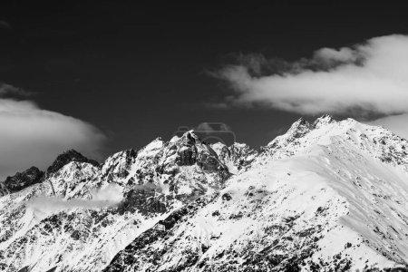 Foto de Altas montañas nevadas de invierno y cielo con nubes en el día del sol. Montañas del Cáucaso. Svaneti región de Georgia. Paisaje tonificado blanco y negro - Imagen libre de derechos