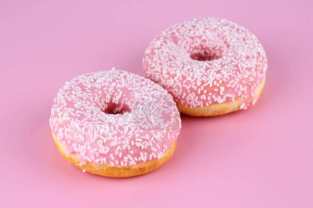 Foto de Dos rosquillas frescas sobre fondo rosa. - Imagen libre de derechos