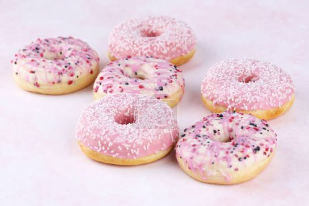 Foto de Muchos donuts frescos de colores sobre fondo rosa. - Imagen libre de derechos