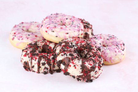 Foto de Muchas rosquillas frescas de colores sobre fondo rosa y amarillo. - Imagen libre de derechos