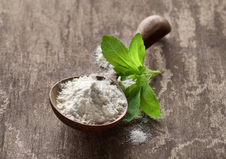 Stevia leaves with powder in wooden spoon