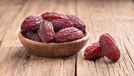 Photo for Arabian dates in closeup on old wooden board - Royalty Free Image