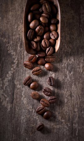 Photo for Coffee beans in closeup on old wooden background - Royalty Free Image