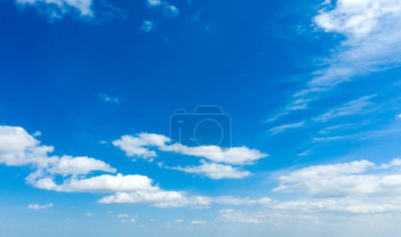 Niebieskie niebo tło z malutkimi chmurami