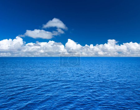 Photo for Clouds on blue sky over calm sea with sunlight reflection - Royalty Free Image