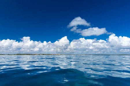 Photo for Clouds on blue sky over calm sea with sunlight reflection - Royalty Free Image