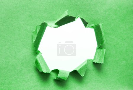 Foto de Un agujero en el papel con los lados arrancados. Papel roto. Con espacio para tu mensaje - Imagen libre de derechos