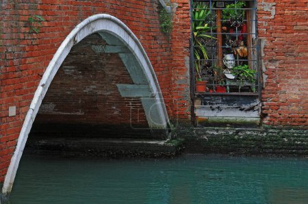 Arc and grilled window in Venice on a gloomy day