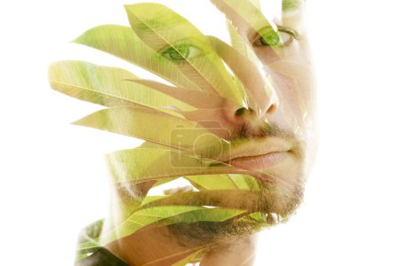 Téléchargez les photos : Portrait d'un visage d'homme associé à une photo de feuilles de palmier en double exposition - en image libre de droit