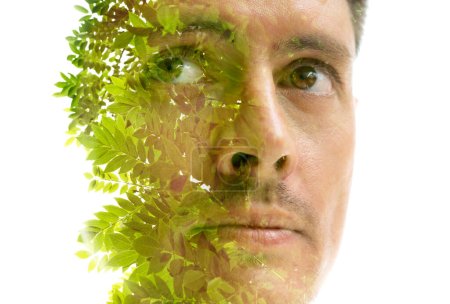 Téléchargez les photos : Portrait double exposition d'un visage d'homme combiné à une photo de branches d'arbres verts - en image libre de droit