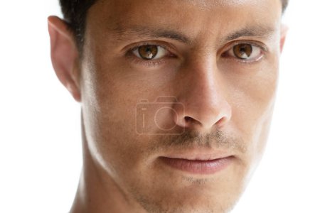 Téléchargez les photos : Gros plan d'un portrait d'un homme aux yeux brun clair regardant attentivement dans la caméra - en image libre de droit
