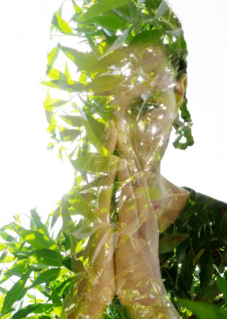 Téléchargez les photos : En utilisant la technique de la double exposition, un jeune homme portrait avec ses paumes ensemble à son visage et son dos à l'appareil photo est mélangé avec une image de feuilles vert vif. - en image libre de droit