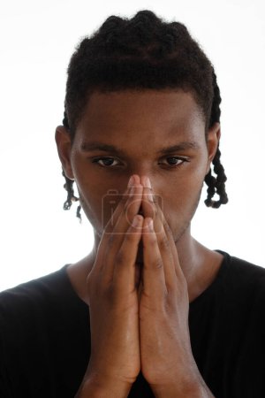 Téléchargez les photos : Portrait d'un jeune homme réfléchi tenant la main sur son visage sur un fond blanc - en image libre de droit