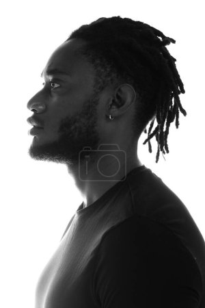 Photo for A high-contrast black and white profile portrait of a man with dreadlocks and an earring - Royalty Free Image