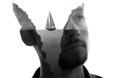 Foto de Retrato de primer plano en blanco y negro de un hombre combinado con una pintura de un barco entre dos rocas en técnica de doble exposición - Imagen libre de derechos