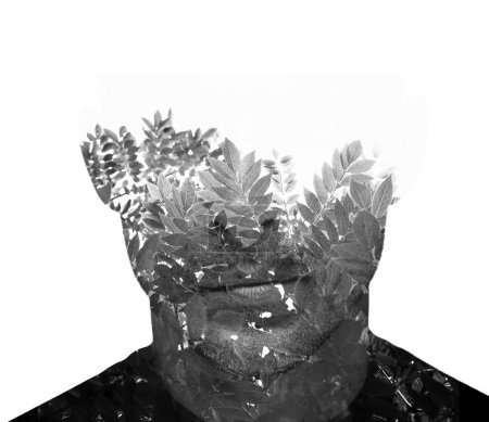 A black and white portrait of a man combined with a photo of small leafy branches in double exposure technique