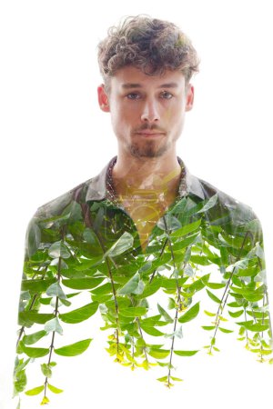 Téléchargez les photos : Un jeune homme portrait plein front combiné avec une photo de pousses vertes dans une technique de double exposition - en image libre de droit