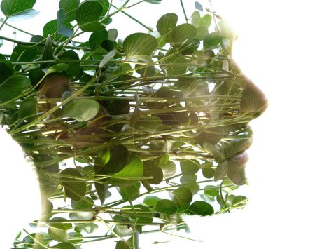Téléchargez les photos : Portrait de profil d'un jeune homme combiné à une photo de végétation verte dans une technique de double exposition, créant un effet visuel intéressant - en image libre de droit