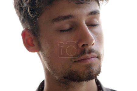 Photo for A close-up portrait of a young Caucasian man with closed eyes on a white background - Royalty Free Image