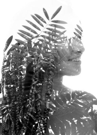Téléchargez les photos : Portrait demi-profil noir et blanc d'une jeune femme fusionné avec une photo de feuillage en double exposition, s'estompant en arrière-plan. - en image libre de droit