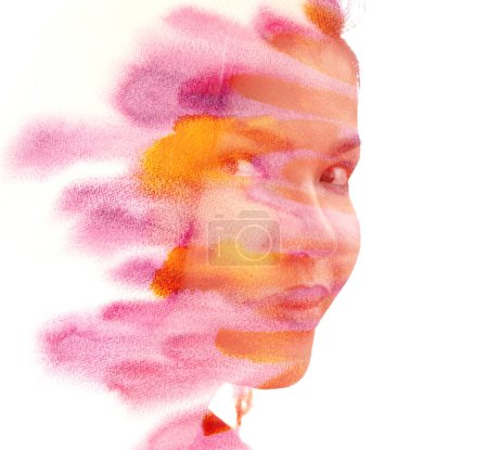 Photo for A half profile portrait of a young Asian woman disappearing into watercolor splashes in a paintography - Royalty Free Image