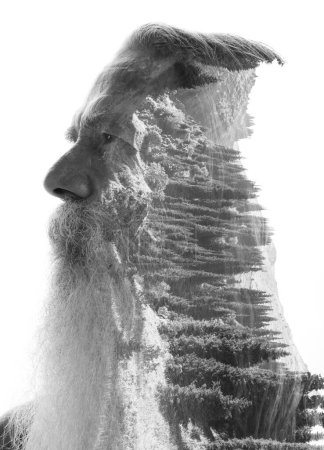 A profile portrait of an old man with a beard and moustache merged with a black and white photo of nature in double exposure