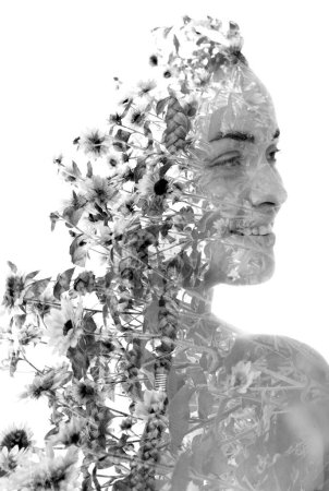 Téléchargez les photos : Portrait demi-profil noir et blanc d'une femme souriante fusionné avec une photo en noir et blanc de fleurs en double exposition - en image libre de droit