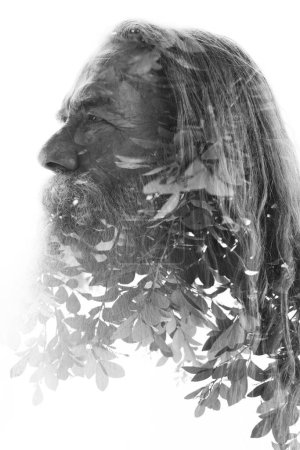 A black and white profile of an old bearded man merged with a photo tree leaves in a double exposure disappearing into a white background towards the boroom