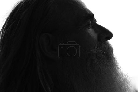 Téléchargez les photos : Portrait noir et blanc de profil bas d'un homme barbu âgé aux cheveux longs et aux yeux fermés - en image libre de droit
