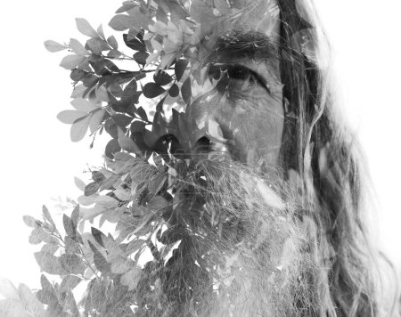 Portrait en gros plan noir et blanc d'un vieil homme barbu fusionné avec une photo de branches d'arbres dans une double exposition