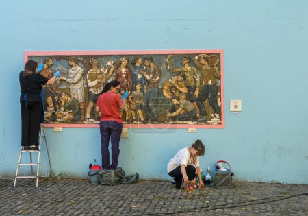 Foto de Buenos Aires, Argentina - 6 de febrero de 2023: Tres mujeres limpian el arte mural de Humberto Cerantonio en La Boca - Imagen libre de derechos