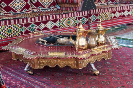 Téléchargez les photos : Cafetières arabes traditionnelles ou qahwa à Dubaï avec table et canapé sur tapis oriental avec charbons chauds - en image libre de droit