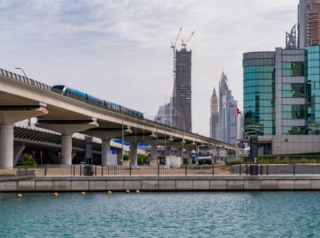 Téléchargez les photos : Dubaï, EAU - 2 avril 2023 : La ligne verte du métro de Dubaï traverse le canal dans le quartier des affaires du centre-ville - en image libre de droit