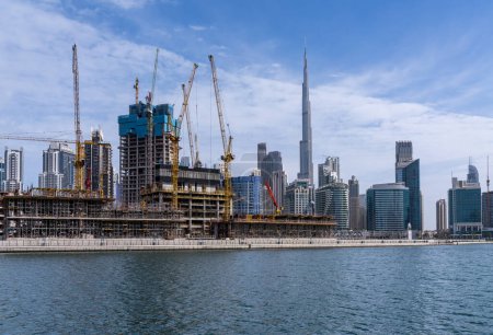 Photo for Dubai, UAE - April 2, 2023: Cranes around new construction of apartments around Business Bay - Royalty Free Image