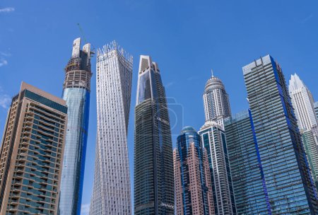 Foto de Dubai, Emiratos Árabes Unidos - 2 de abril de 2023: Torre Cayan entre altos bloques de apartamentos junto al agua en Dubai Marina - Imagen libre de derechos