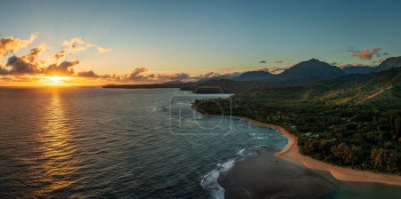 Dramatically wide panorama looking east from Tunnels Beach on Kauai towards the rising sun and Hanalei bay