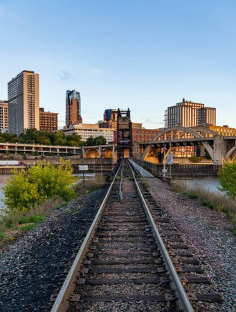 Téléchargez les photos : Paysage urbain tôt le matin de St Paul et villes jumelles dans le Minnesota regardant vers le bas des rails du pont ferroviaire - en image libre de droit