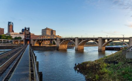 Téléchargez les photos : Paysage urbain tôt le matin de St Paul et villes jumelles dans le Minnesota et le fleuve Mississippi avec pont ferroviaire - en image libre de droit