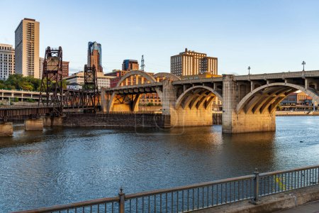 Téléchargez les photos : Paysage urbain tôt le matin de St Paul et villes jumelles dans le Minnesota et le fleuve Mississippi avec pont ferroviaire - en image libre de droit